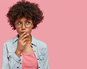 Young woman with glasses making an inquisitive face 