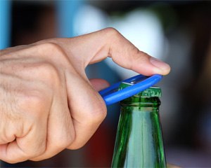 Man opening a bottle with a bottle opener