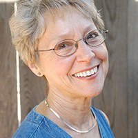 Smiling older woman standing by tree