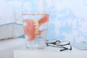 dentures in Milwaukee soaking in glass at bedside