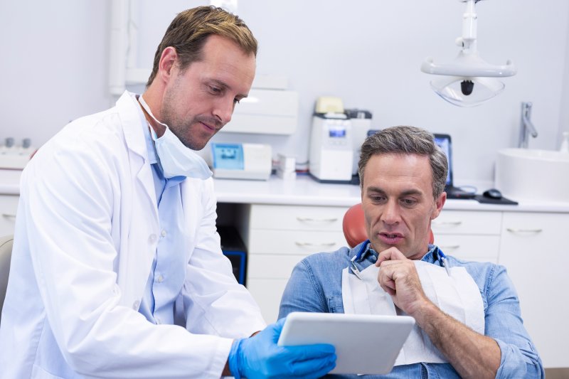 A man talking to his dentist during a dental implant consultation