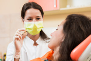 dentist holding woman's tooth