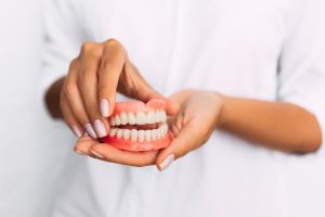 Woman holding denture in Milwaukee.